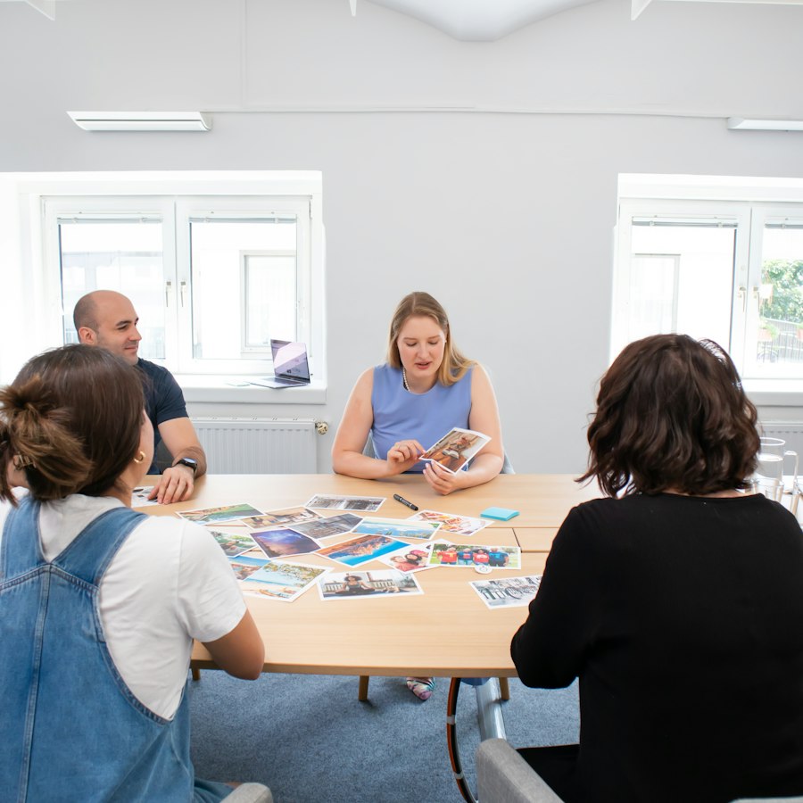 Petit groupe en atelier autour d’une table couverte de cartes-photos
