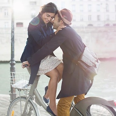 Couple s’embrassant en ville, à côté d’un vélo