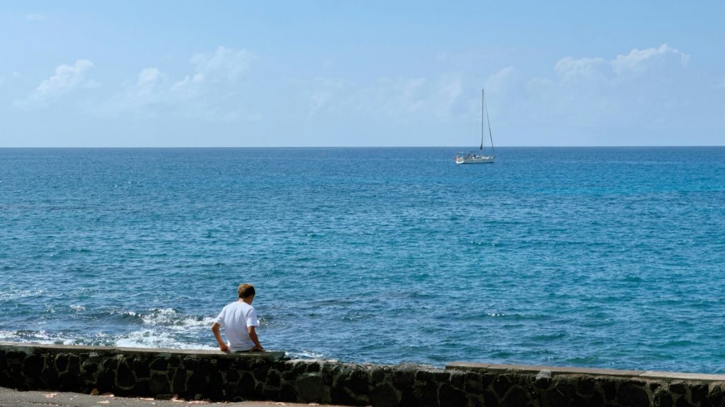Homme assis face à l'océan, un moment de calme intérieur